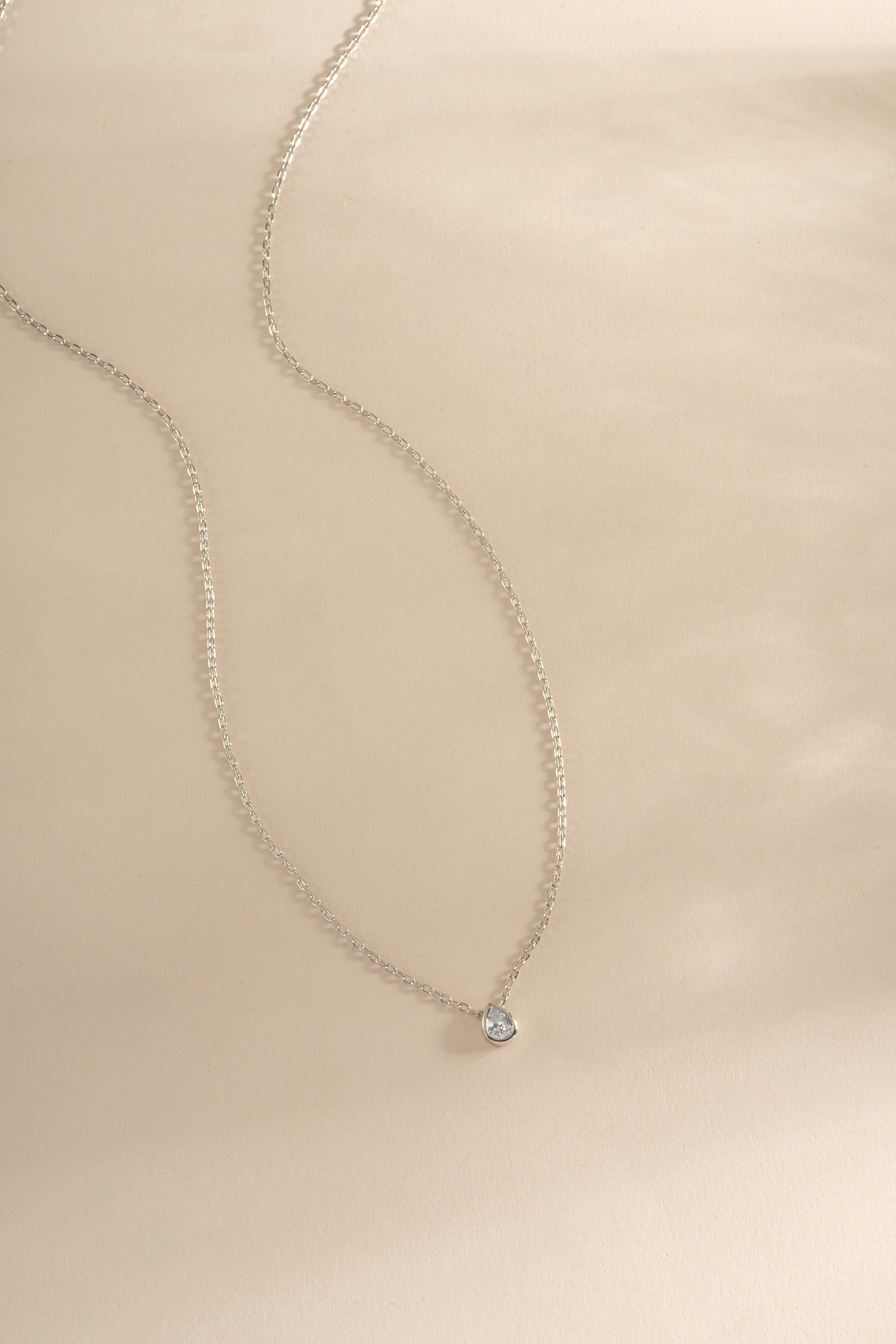 Sterling silver tear drop pendant necklace with sparkling pear-shaped diamond by Sami Jewels, showcasing elegant jewelry design.