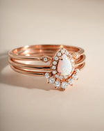 Close-up of Sami Jewels Pear Opal Ring Set featuring rose gold bands with pear-shaped opal stones.