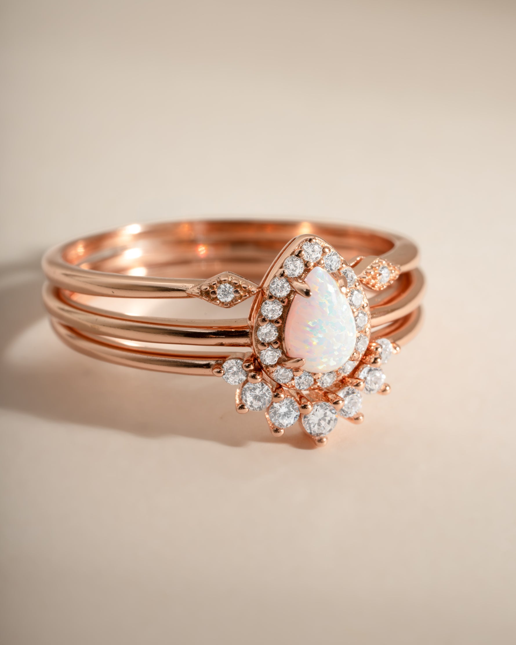 Close-up of Sami Jewels Pear Opal Ring Set featuring rose gold bands with pear-shaped opal stones.
