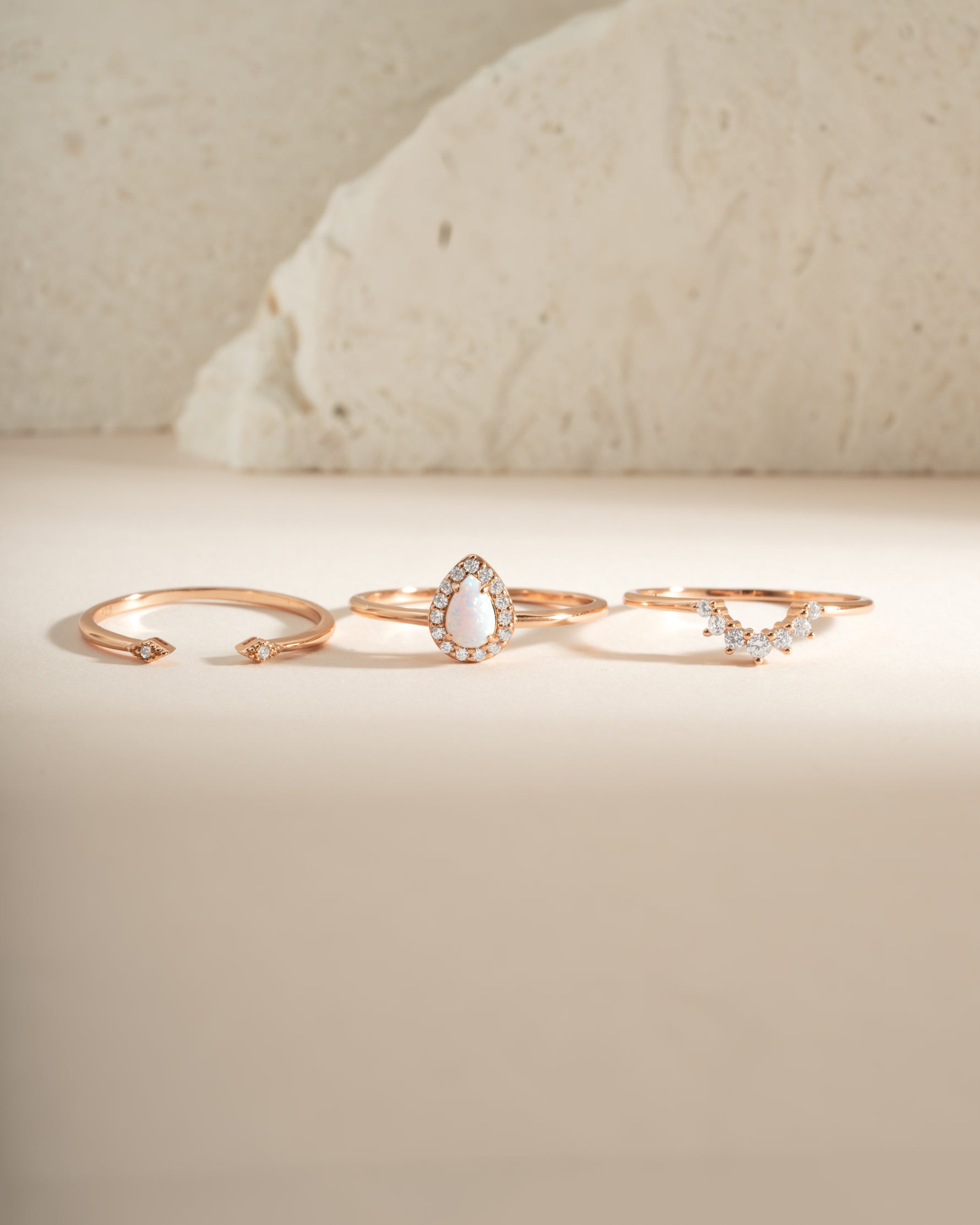 Set of three Sami Jewels pear opal rings in rose gold, featuring elegant gemstone designs and intricate band details.