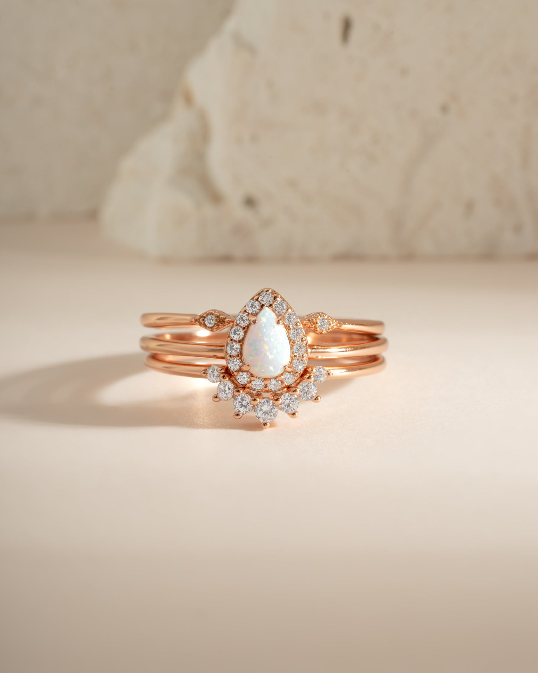 Sami Jewels pear opal ring set with rose gold bands, featuring multiple delicate rings with pear-shaped opal stones.