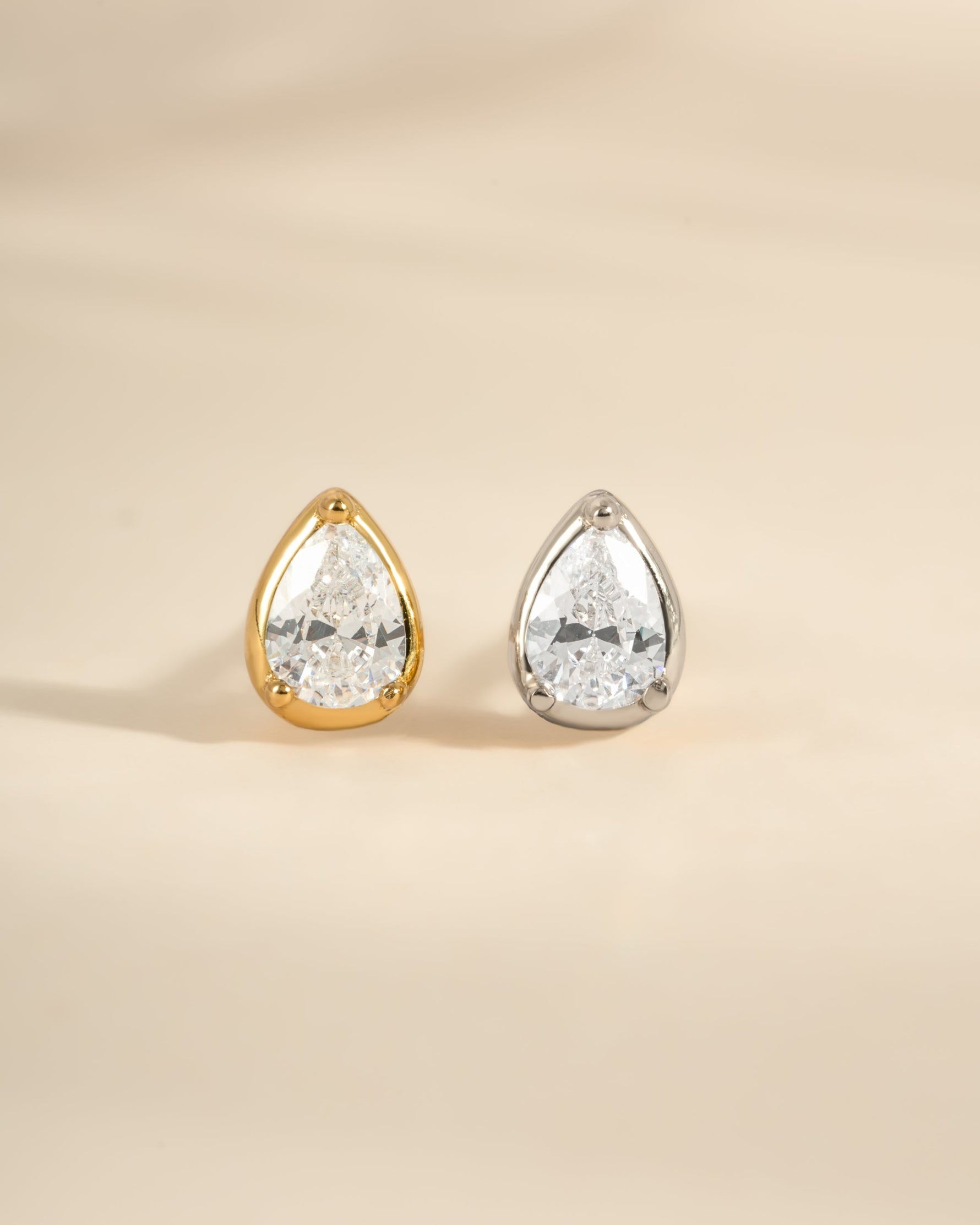 Gold and sterling silver tiny pear-shaped stud earrings by Sami Jewels, close-up of minimalist jewelry accessory.