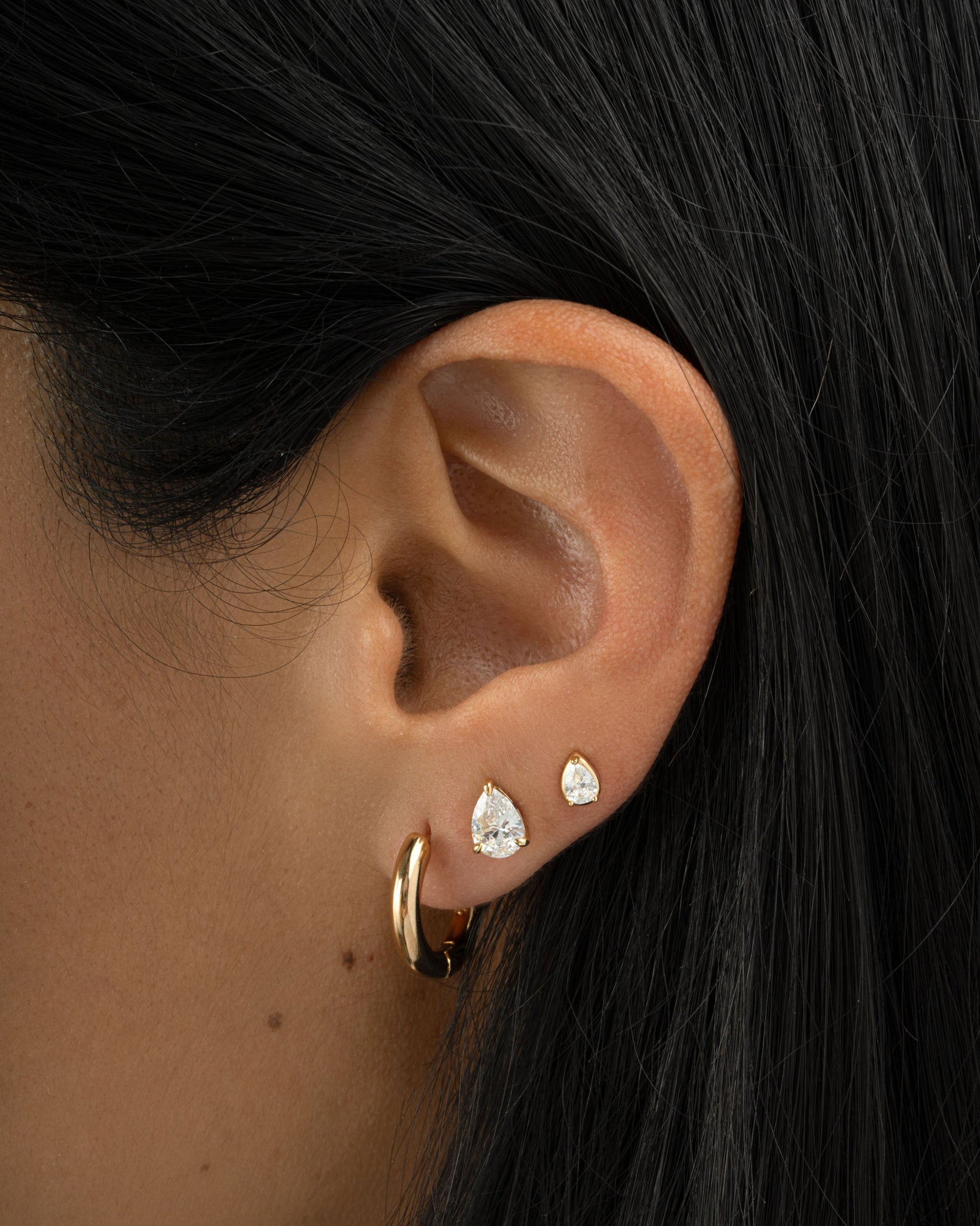 Gold Tiny Pear Stud Earrings from Sami Jewels worn on a model, showcasing small, elegant pearl-shaped jewelry.