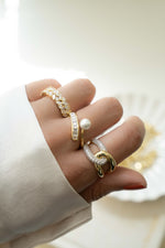 Gold Pearl Baguette Ring by Sami Jewels worn on a model's finger, showcasing elegant design and sparkling pearl accents.