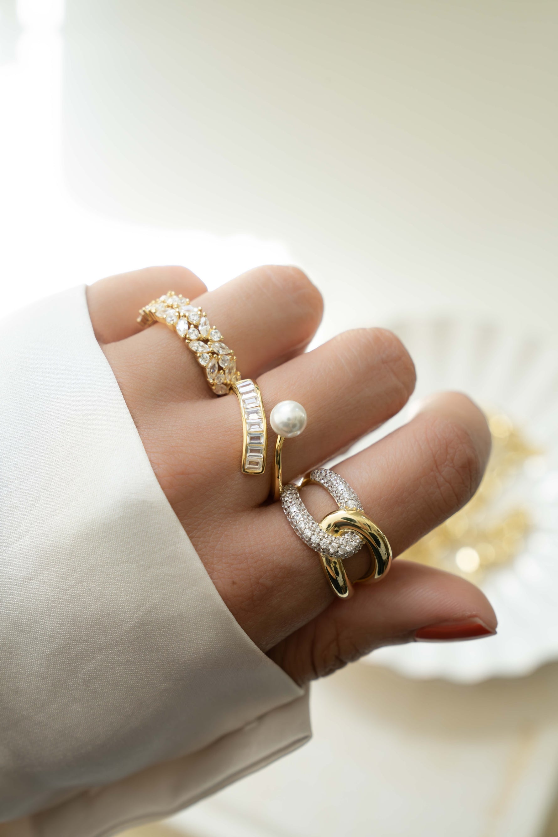 Gold Pearl Baguette Ring by Sami Jewels worn on a model's finger, showcasing elegant design and sparkling pearl accents.