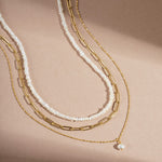 Sami Jewels Pearl Summer Necklace Stack flatlay, with pearl beaded necklace, paperclip necklace, and pendant pearl necklace in gold. 