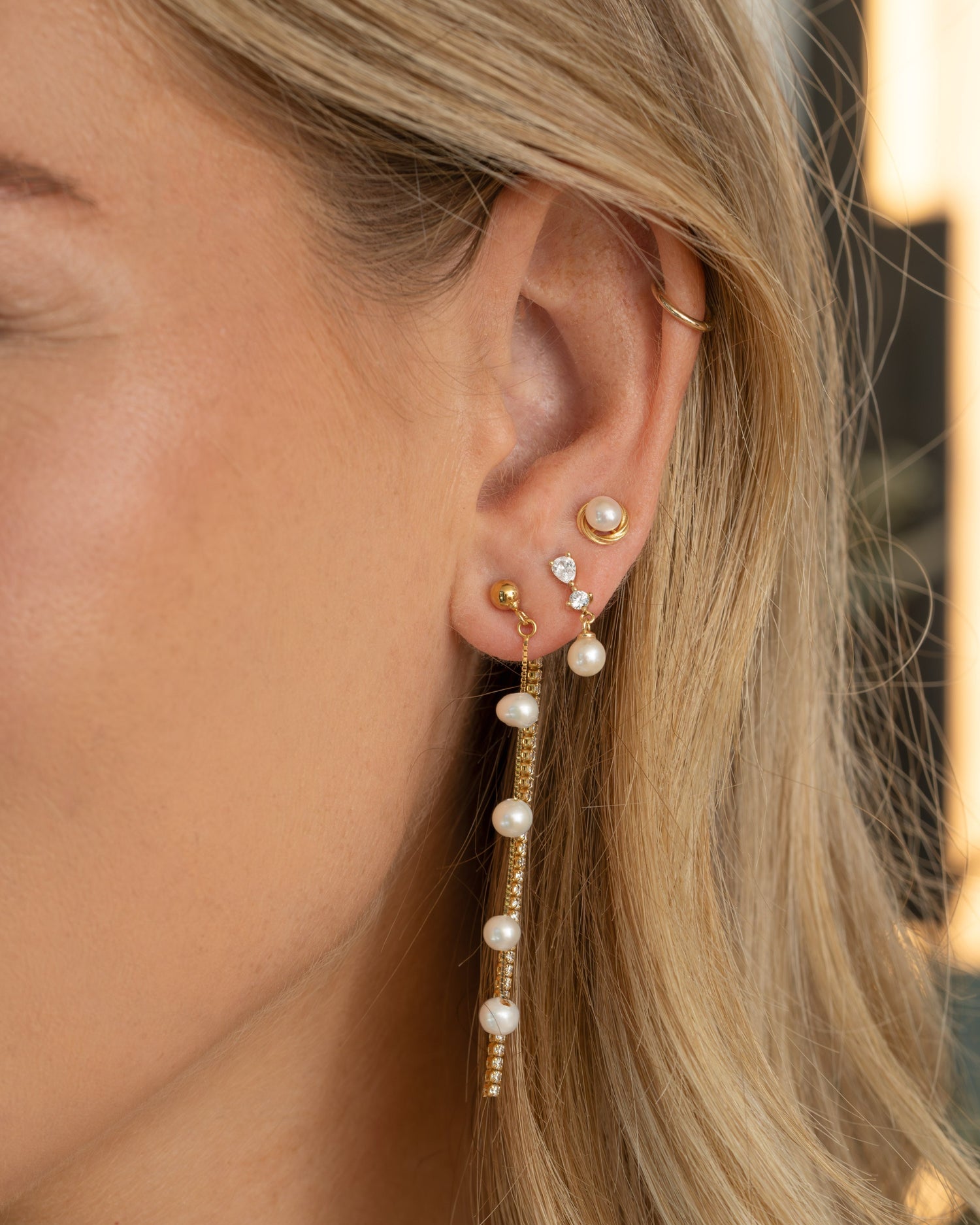 Sami Jewels dangling pearl bead earrings with gold tassels, featuring elegant pearl and gold detailing on a model.