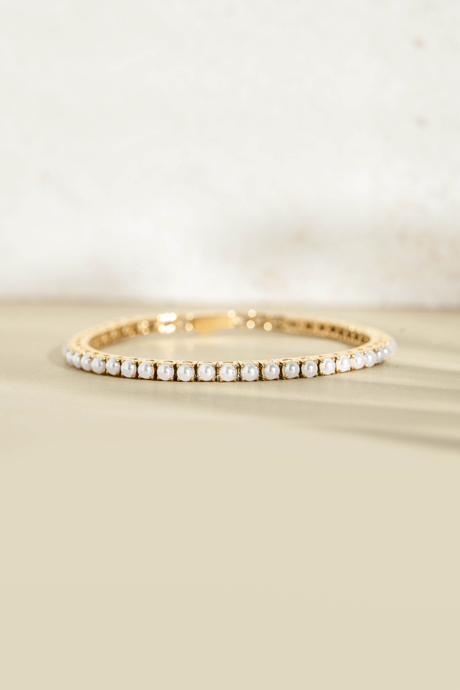 Sami Jewels SS Pearl Tennis Bracelet with gold stainless steel links and freshwater pearls, front view, waterproof design.