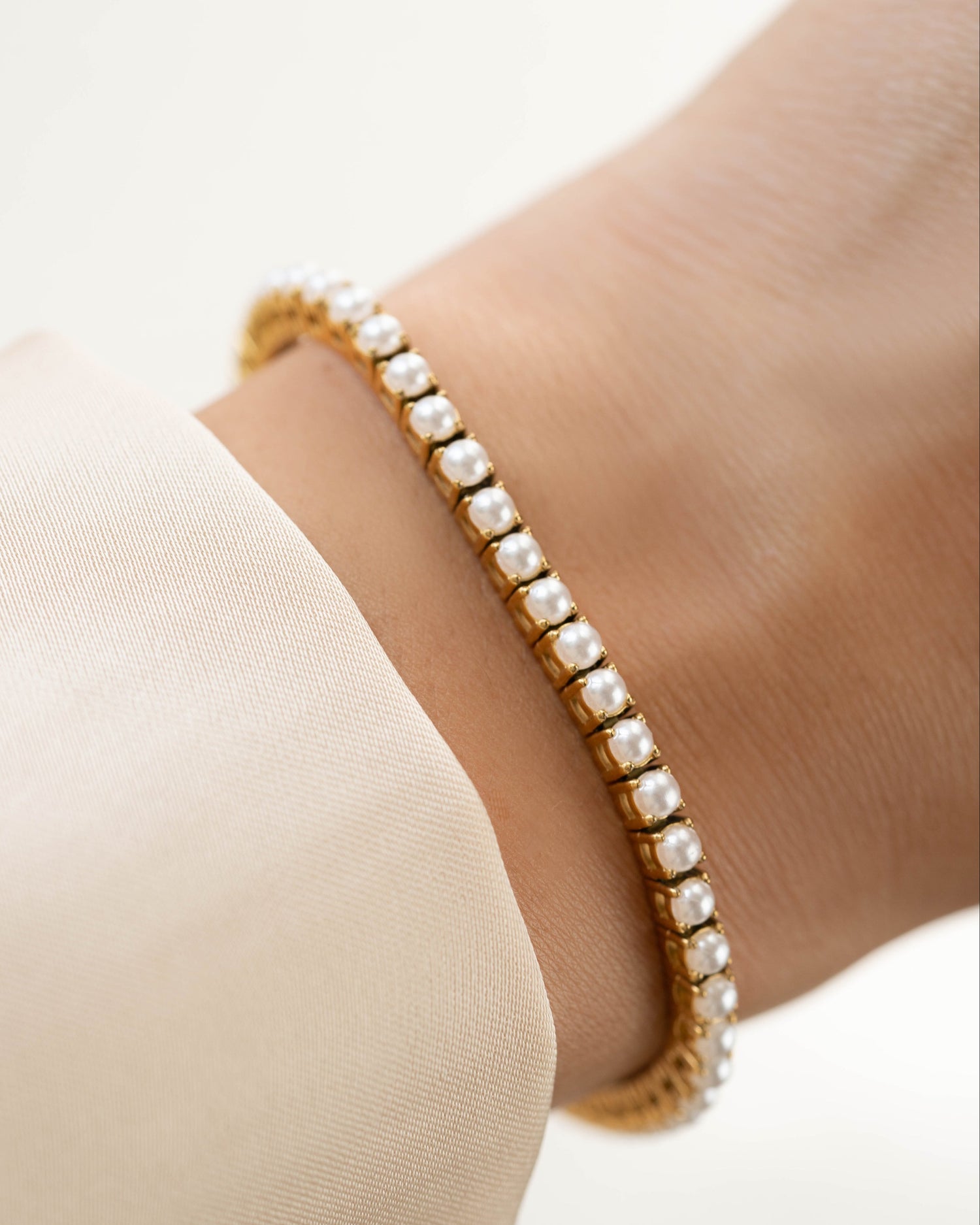 Gold stainless steel SS Pearl Tennis Bracelet by Sami Jewels featuring elegant freshwater pearls on a sleek bracelet.