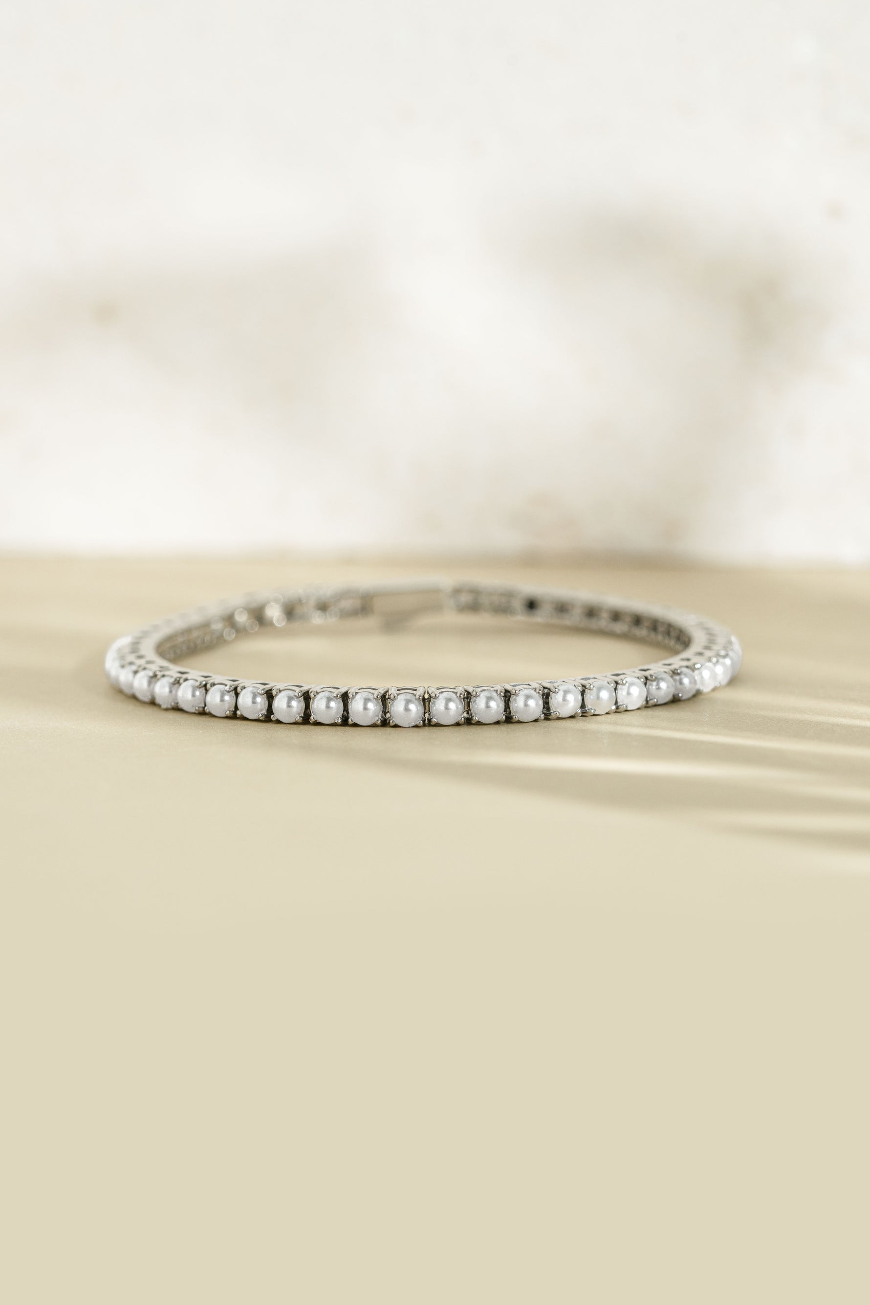 Sami Jewels SS Pearl Tennis Bracelet featuring silver stainless steel and waterproof design, front view of elegant pearl beads.