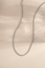 Sami Jewels SS Pearl Tennis Necklace with silver stainless steel chain and freshwater pearls, front view displaying elegant design.