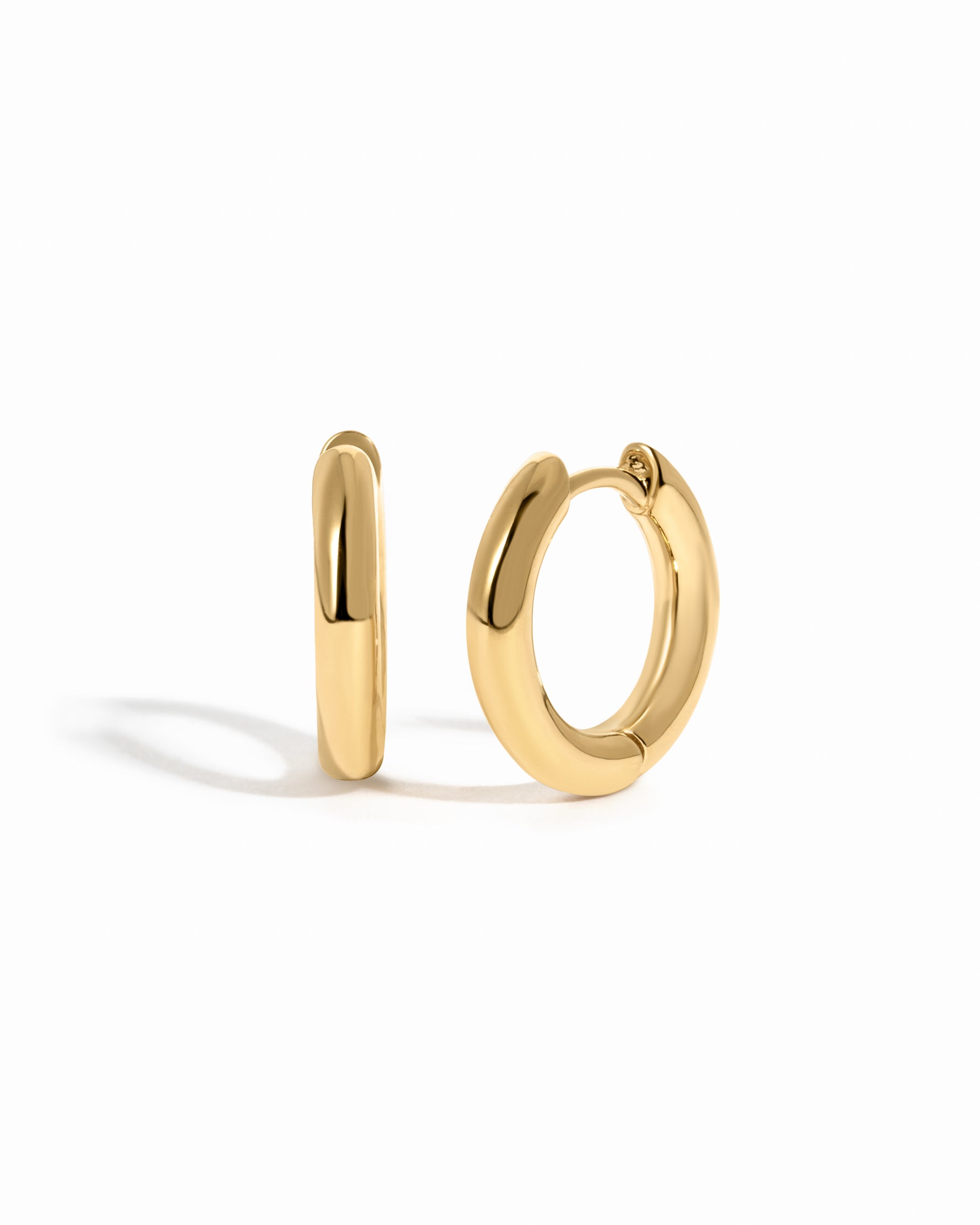 plain minimalist huggie hoops in gold in 10mm on a white background