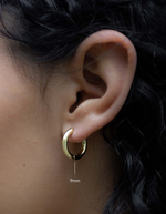 plain huggie hoop earring in 9mm in gold on models ear