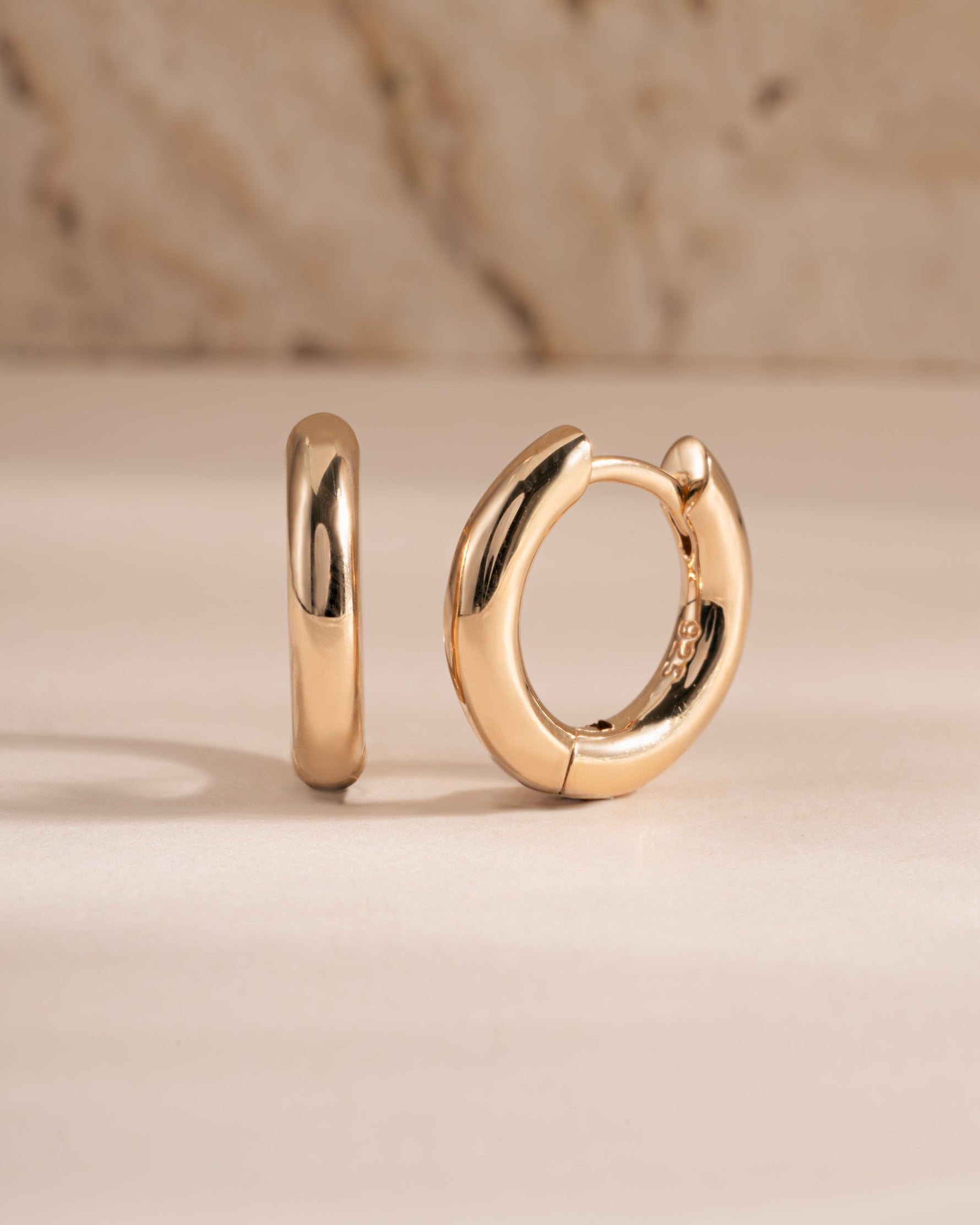 plain huggie hoop earring in gold in 9mm side view