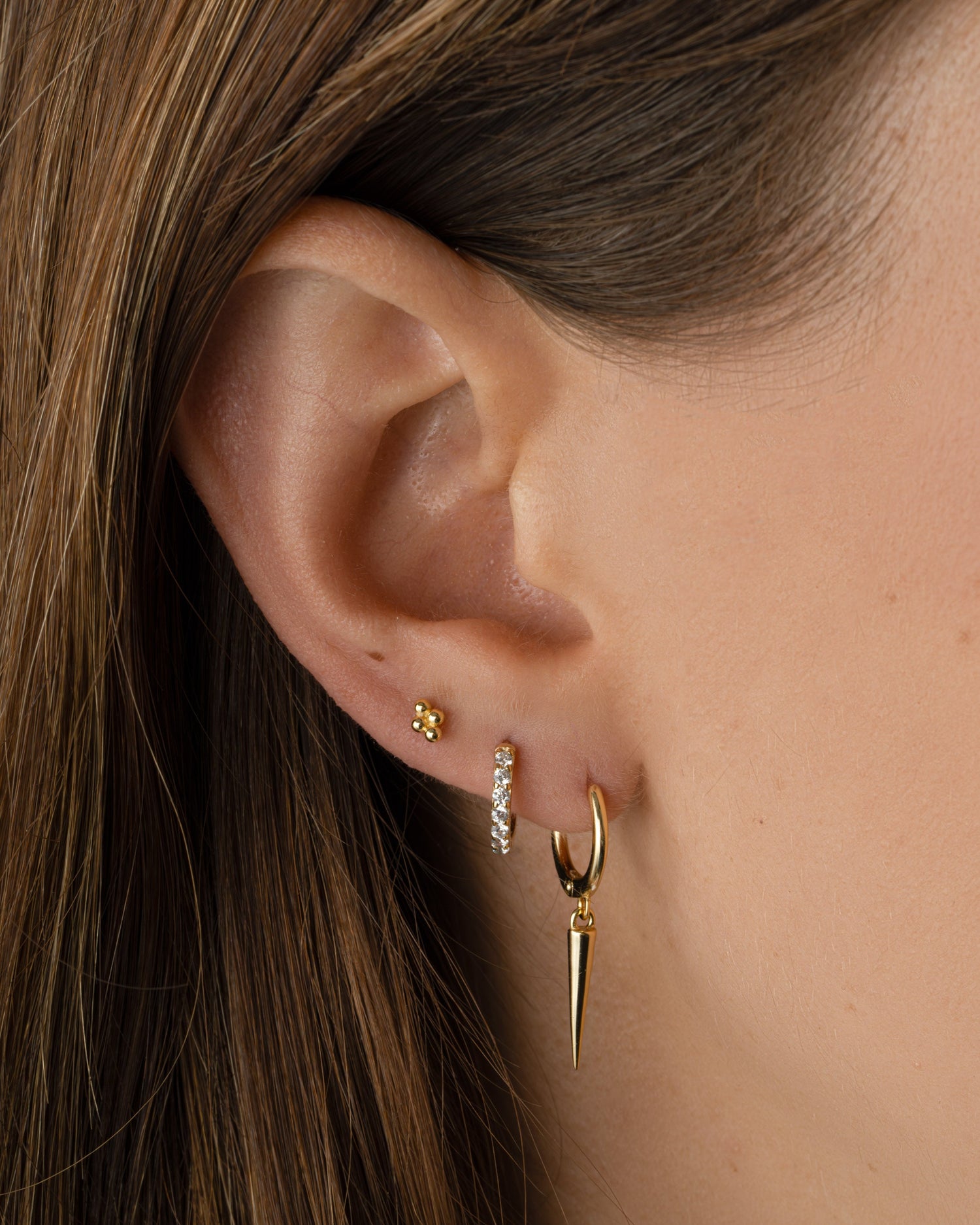 Gold plain spike huggie earrings by Sami Jewels, close-up view showing simple, sleek design and secure hoop style.