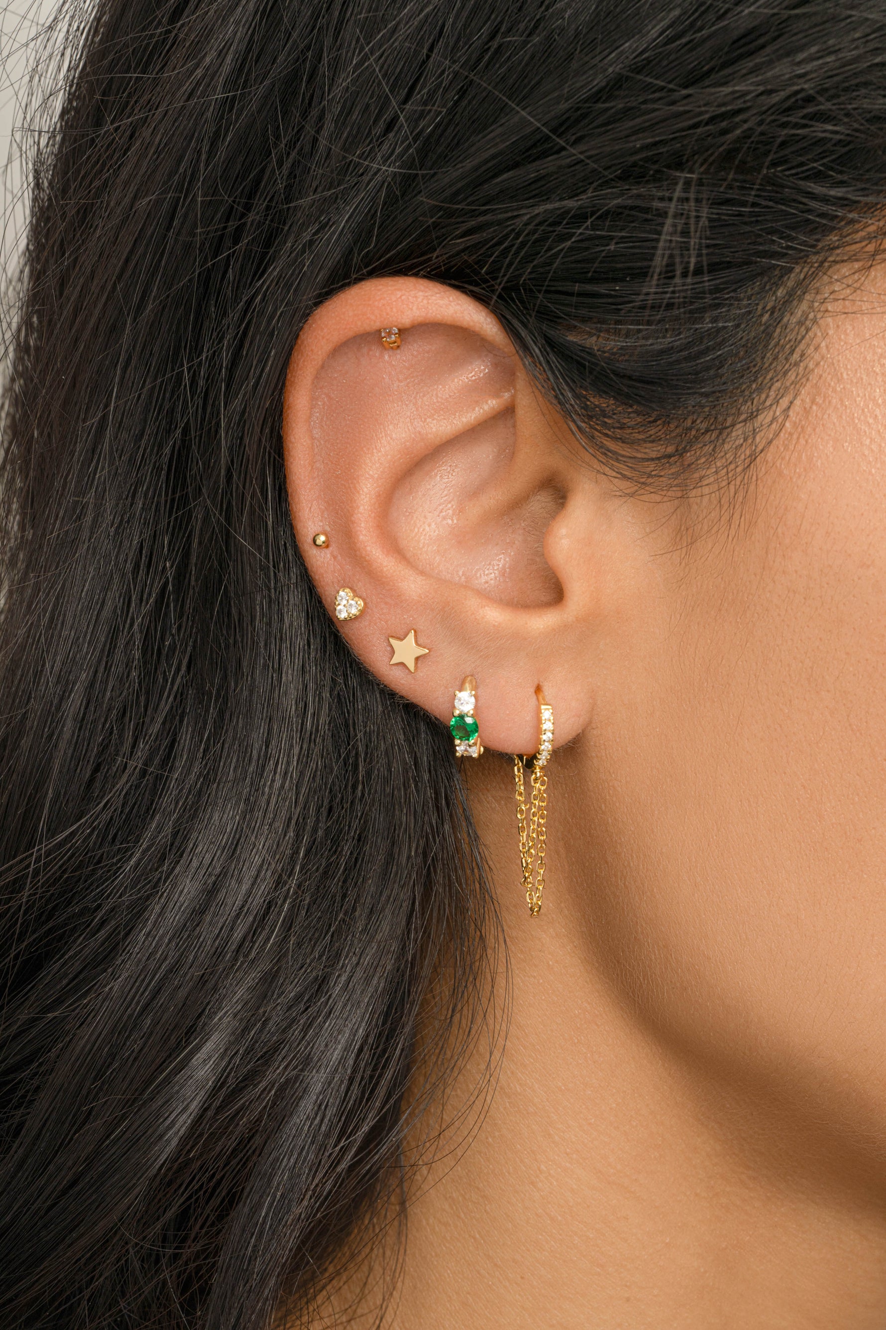 Gold plain star stud earrings from Sami Jewels, close-up of simple star-shaped stud jewelry on a model.