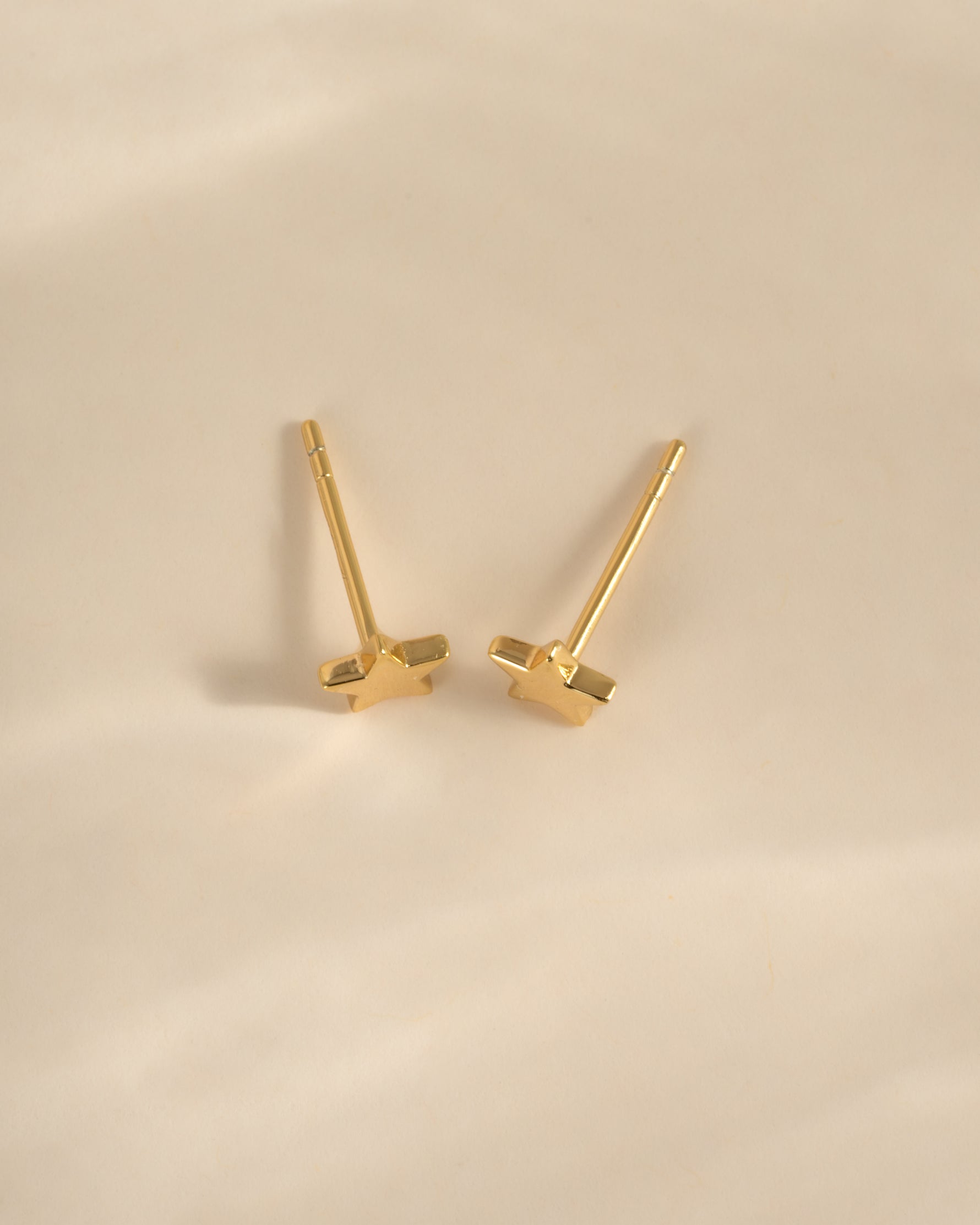 Gold plain star stud earrings from Sami Jewels, top view showing small, minimalist star design in shiny gold finish.