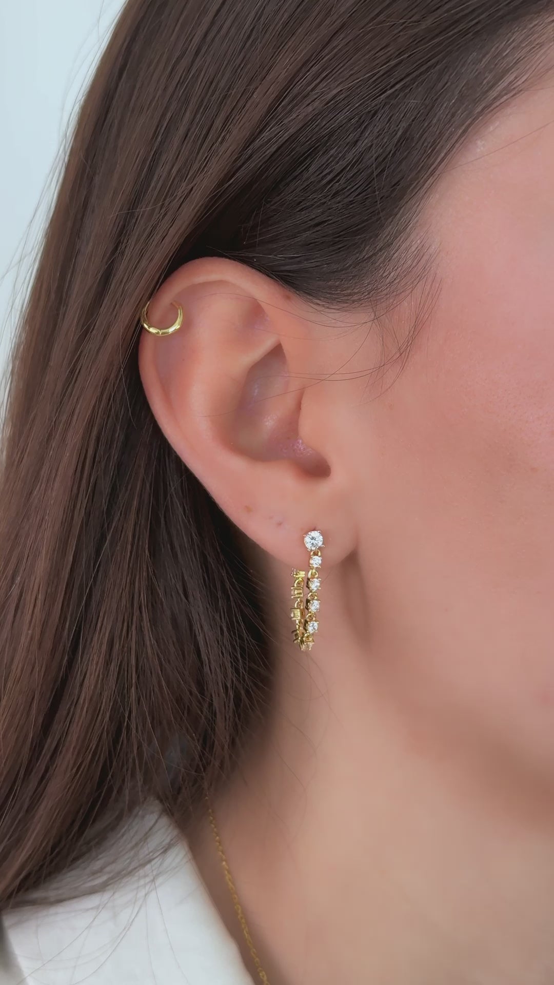 video of model wearing tennis chain bridal jewelry, blending dainty gold hanging earrings with helix earrings.