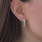 Delicate wedding earrings with teardrop gemstones, worn by the model for bridal inspiration.