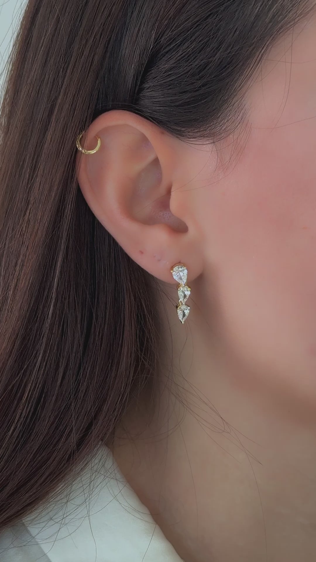 Delicate wedding earrings with teardrop gemstones, worn by the model for bridal inspiration.