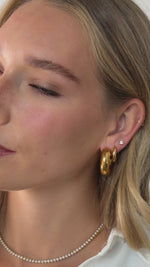 chunky open hoop earring styled in gold stainless steel on model video