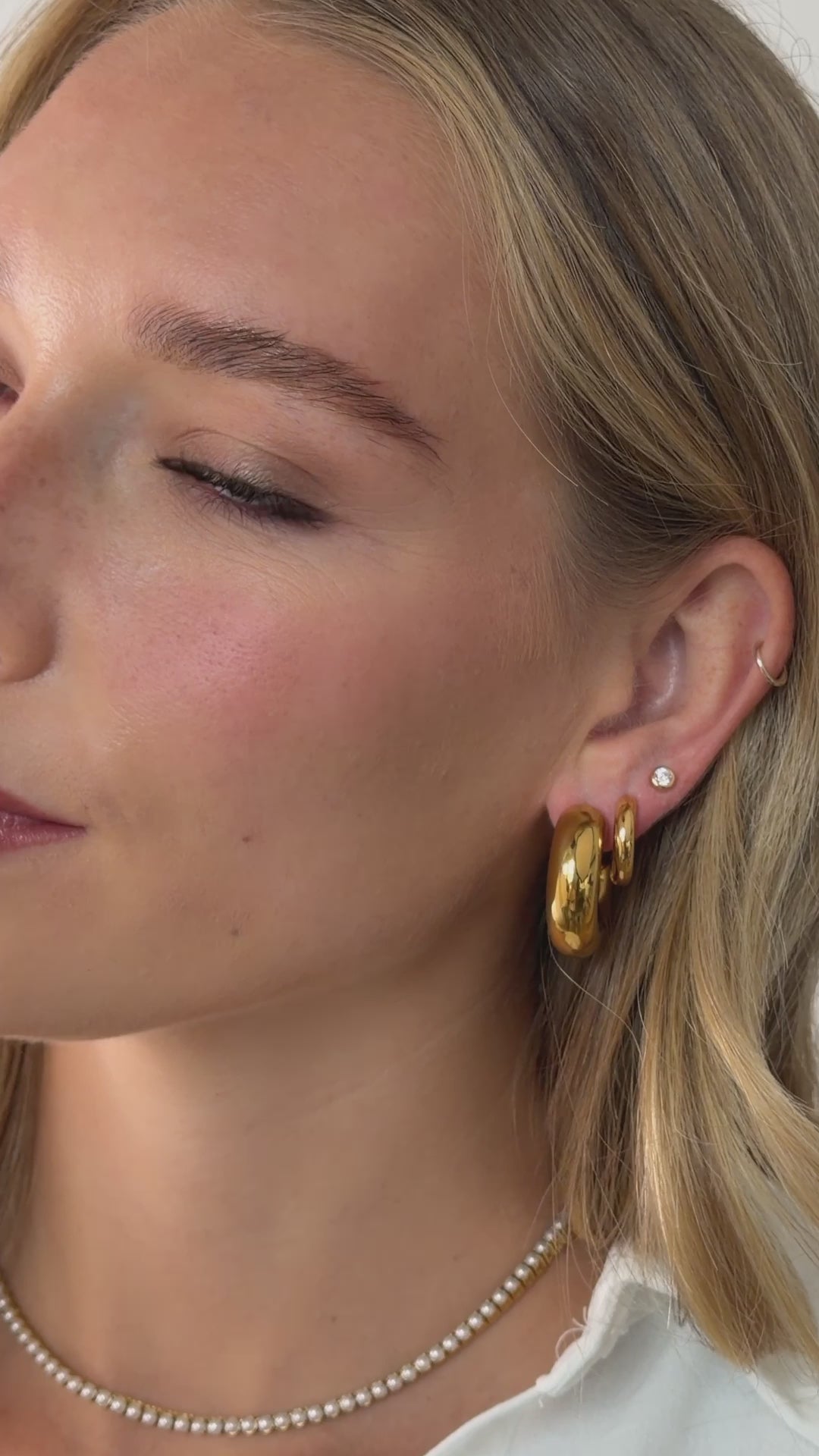 chunky open hoop earring styled in gold stainless steel on model video