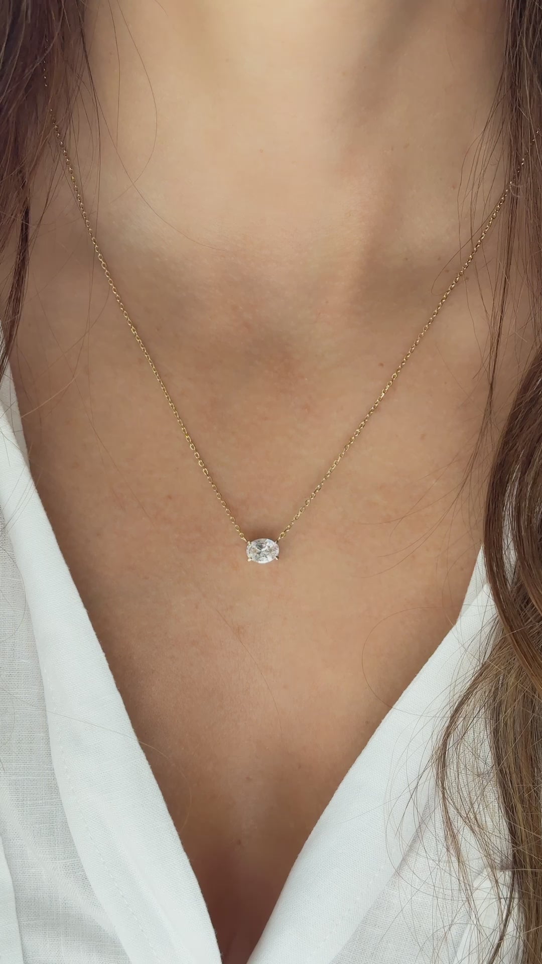 Video of model wearing gold solitaire necklace with oval diamond