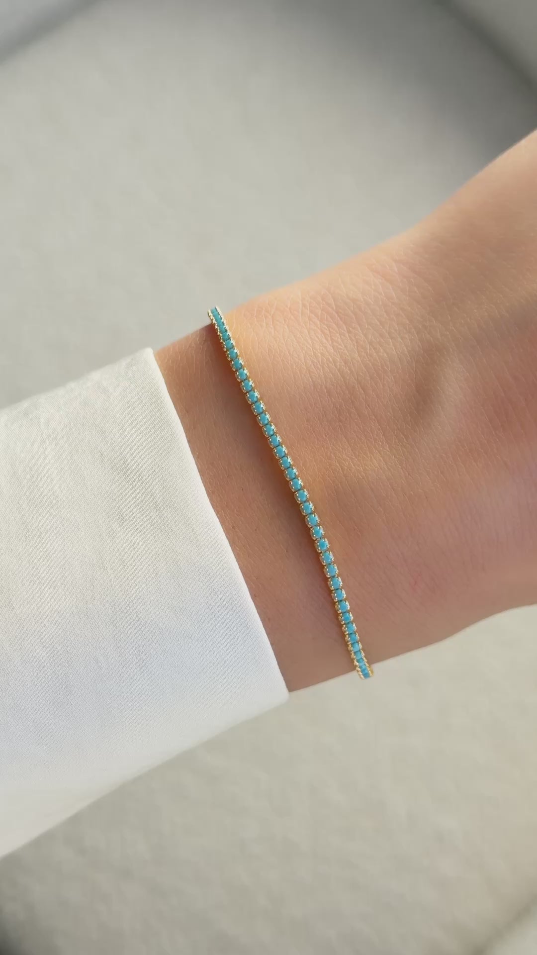 turquoise tennis bracelet in gold on models wrist