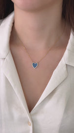 model wearing heart-shaped black onyx necklace styled with a classic white top.  