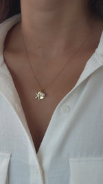 beach charm necklace with a starfish charm, palm tree medallion charm, and a pear charm in gold