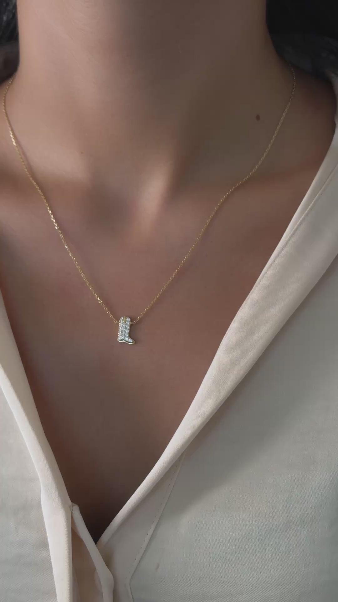 gold cowboy boot pendant necklace made with cz stones on model
