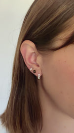 black flower stud earrings in gold in models second hole piercing