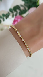 bead and bezel tennis bracelet in gold on model