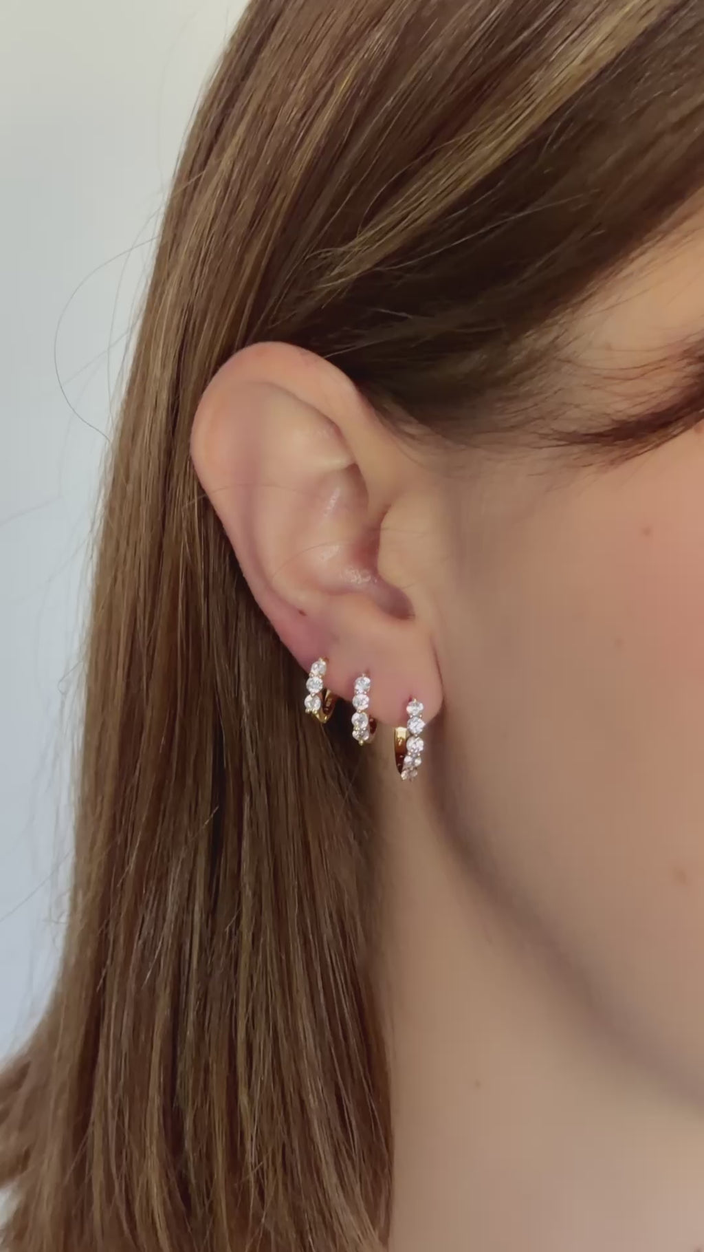 diamond huggie hoop earrings stacked in gold on models ear video 