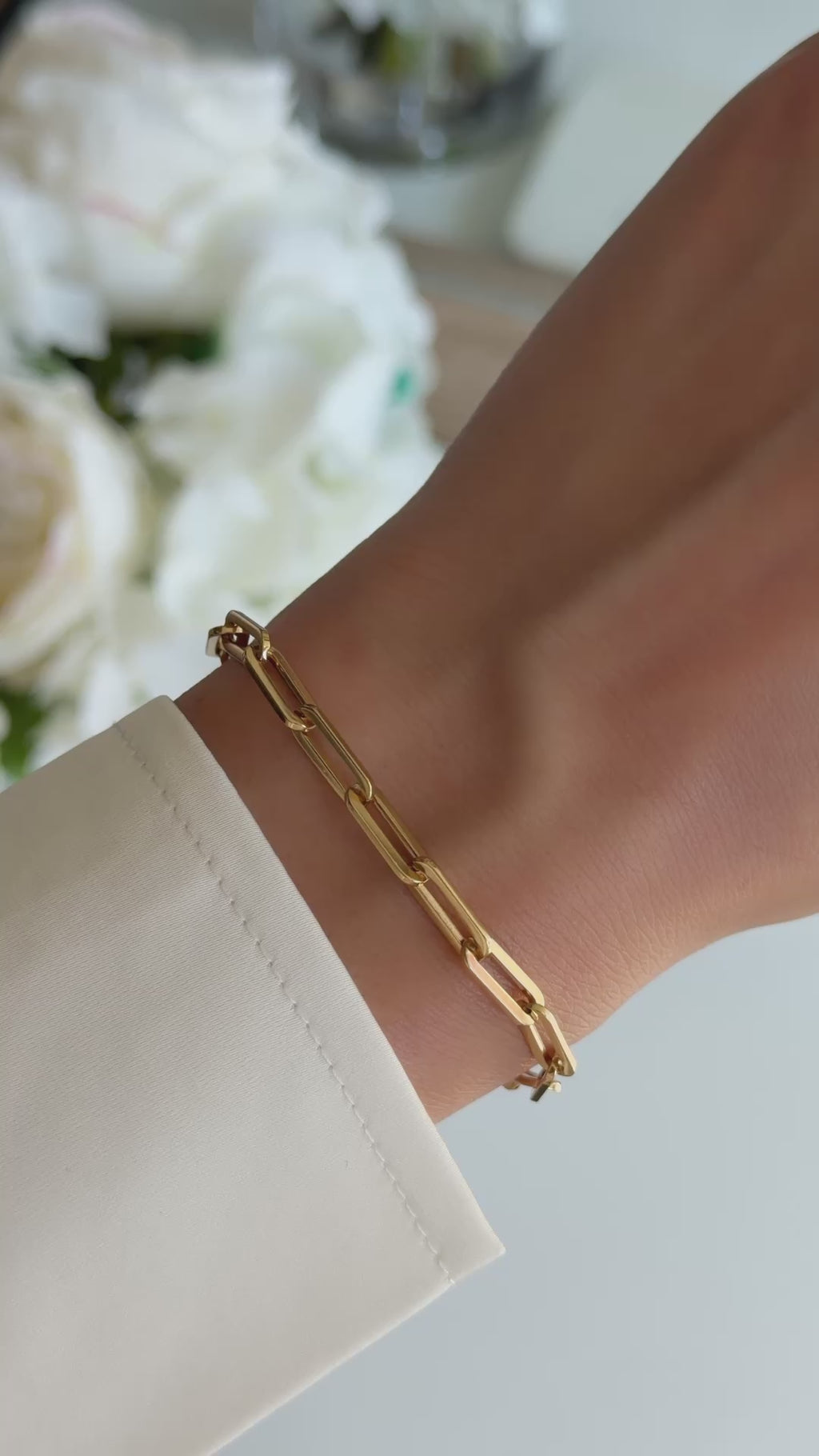 paperclip chain bracelet in gold on models wrist