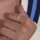 Video of model wearing dainty gold diamond ring set with cozy white and blue striped sweater