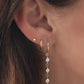 Video of woman wearing 3 gold diamond earrings, a cz diamond drop earring, simple gold huggie hoop, and tiny diamond stud earring.