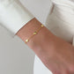 video of the gold charm bracelet styled solo on a wrist, complementing a casual chic outfit with a touch of elegance.