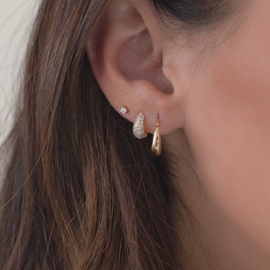 Video of model wearing multiple gold earrings and chunky gold hoops