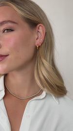 thick huggie hoop earring stack in gold stainless steel on models ear video