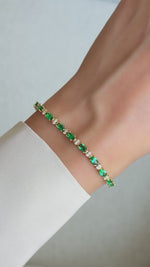 Video of gold oval-cut green tennis bracelet with alternating round white stones featured on wrist.