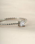 Sami Jewels sterling silver princess cut ring with beaded band, side view showcasing elegant design and sparkling gemstone detail.