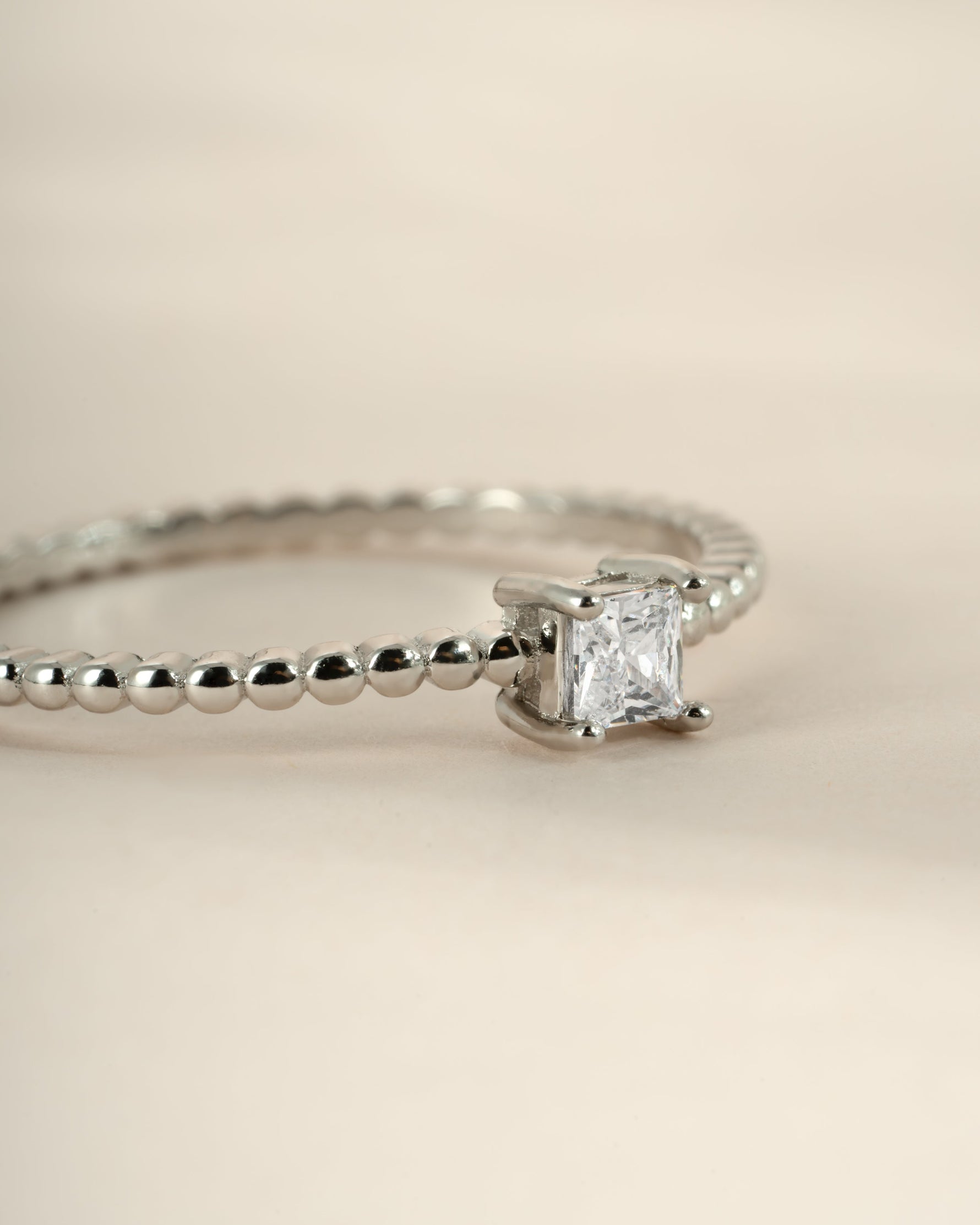 Sami Jewels sterling silver princess cut ring with beaded band, side view showcasing elegant design and sparkling gemstone detail.
