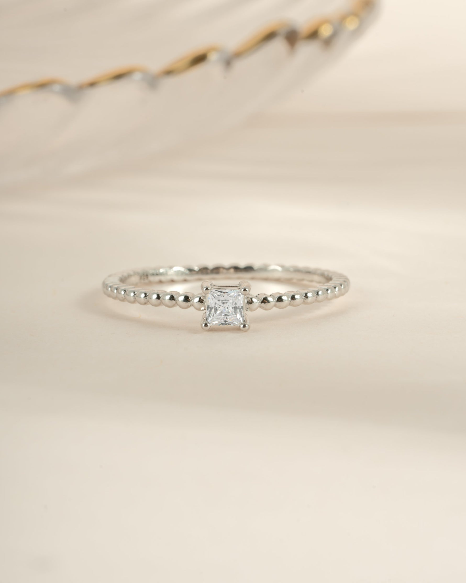 Sami Jewels princess cut ring with a beaded band in sterling silver, showcasing a sparkling princess-cut gemstone and detailed beaded design.