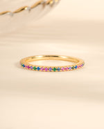 Gold Rainbow Eternity Ring by Sami Jewels featuring colorful rainbow gemstones in a continuous band design.
