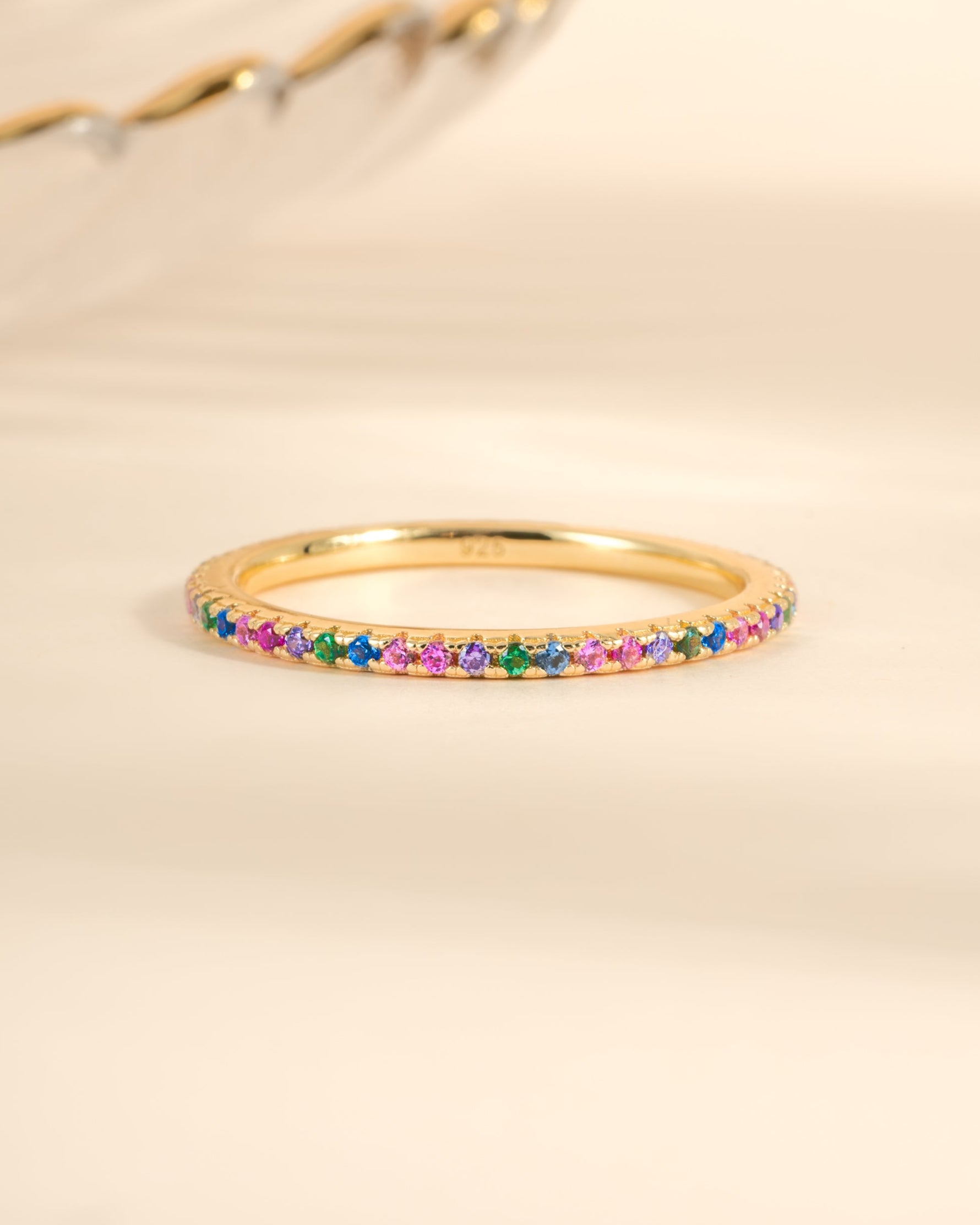 Gold Rainbow Eternity Ring by Sami Jewels featuring colorful rainbow gemstones in a continuous band design.