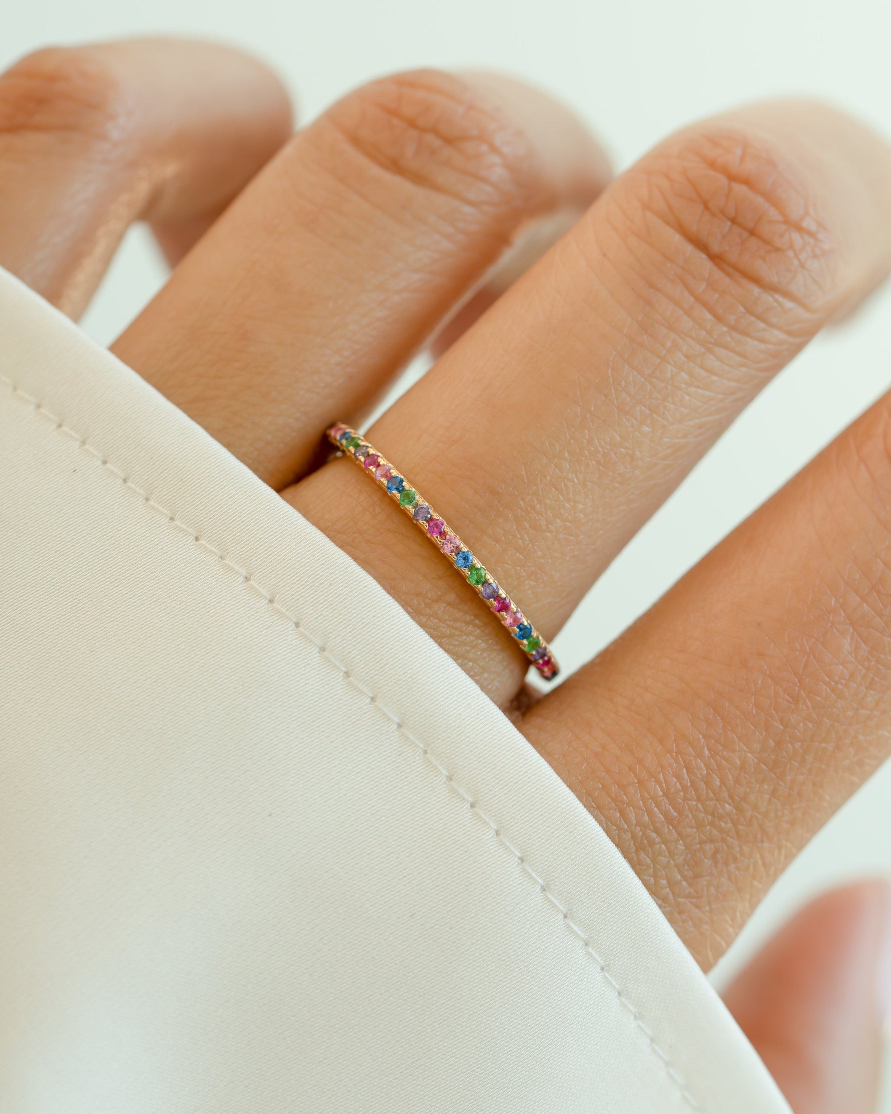 Gold Rainbow Eternity Ring by Sami Jewels featuring multicolor rainbow gemstones encircling the band.