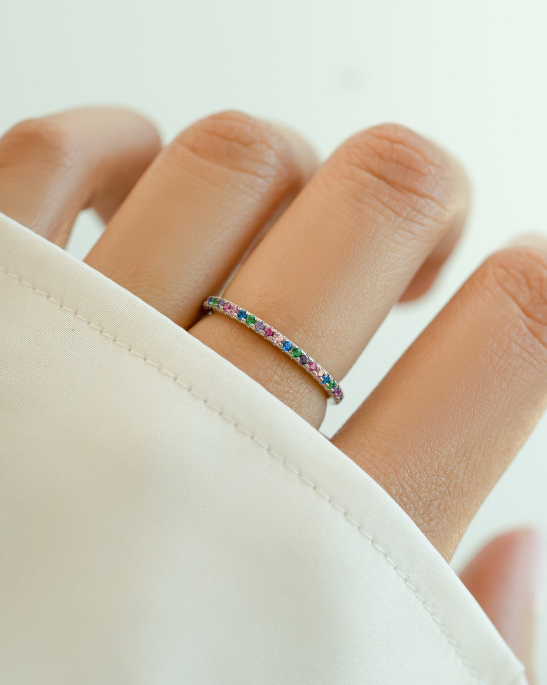 Sami Jewels rainbow eternity ring with colorful gemstone in sterling silver, showcasing a continuous rainbow design.