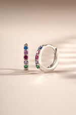 Sterling silver 7mm rainbow studded huggie earrings by Sami Jewels, featuring colorful rainbow accents and a secure hoop design.