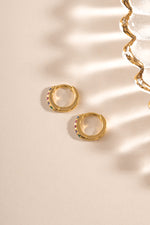 Gold 7mm rainbow studded huggie earrings by Sami Jewels shown in side profile view.